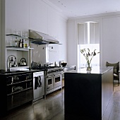 An open-plan kitchen in a period building with a free-standing kitchen counter