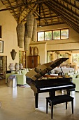 A piano and a bench in an open-plan living room in a South African country house