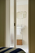 An open, sliding glass door with a view into a shabby chic bathroom