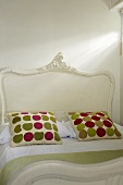 Pillows with colorful dots on a white antique bed