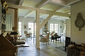 Free-standing wooden beams in an open-plan living room in a renovated farm house