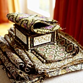 A selection of brocade patterns and an ethnic wooden box