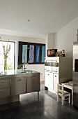 A kitchen counter and furniture in cool stainless steel