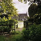Blick vom verwilderten Garten auf altes Bauernhaus