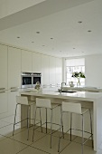 Design in white - a kitchen counter with designer bar stools