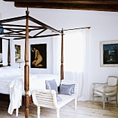 A four poster bed with an elegant wooden frame and Rococo style chairs