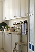 A view into a country house kitchen with white wooden cupboards