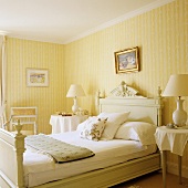 An antique country house-style bed in a bedroom with yellow and white striped wallpaper