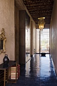 A hallway with a view - polished concrete floor and a chandelier hanging from the wooden ceiling