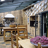 An open kitchen with wood panelled walls and a dining area in the conservatory