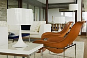 Brown leather bucket chairs and white table lamps in a living room