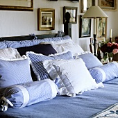 Blue and white cushions on a bed