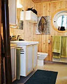 Bathroom - a washstand in front of a wood panelled wall