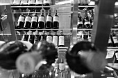 A black and white image of wine displayed on a glass shelf
