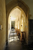 Blick durch gotischen Spitzbogen auf langgestrecktem Kirchenflur mit Bartischen