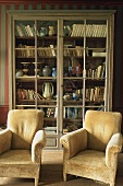 Old fashioned plush armchairs and a cabinet