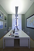 A white desk with indirect lighting in front of a grey wall