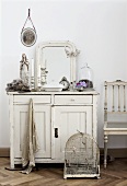 Bird cage in front of chest of drawers (country house style) with mirror