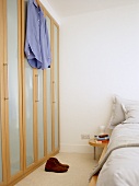 Bedroom with fitted wardrobe with wooden framed doors.