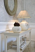 Vase and table lamp made from white ceramic with fabric shade on a table