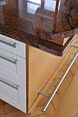 Central island unit with granite worktop in contemporary kitchen