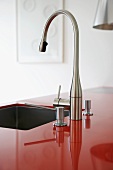 Chrome tap fitting over sink in modern kitchen