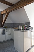 Moderne Küche mit weißen Schrankfronten, Arbeitsplatte mit Rückwand und Boden aus Granit