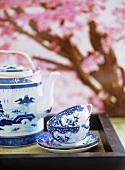 A detail of a Japanese blue and white china cups and saucers and teapot on tray