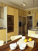 Essbereich in offener Küche mit gelben Schrankfronten
