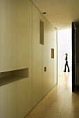 White built-in cupboards with shelf opening in a hallway