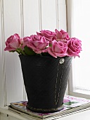 Pink roses in a black vase made from recycled tyre