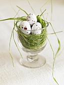 A nest in a glass with speckled eggs