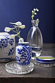 Chinese vases with white and blue painted decoration and white larkspur in glass vases