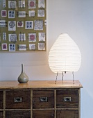 A table lamp on a rustic wooden chest of drawers