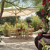 Tisch mit Stühlen und Sonnenschirm auf der Terrasse einer spanischen Villa