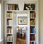 Bücherregale über schmaler Tür mit Blick ins Esszimmer