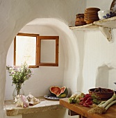 Muscheln und Wassermelone auf Ablage aus Stein unter Fenster in Alkoven im Mediterraner Küche und Gemüse auf Arbeitsplatte