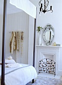 Venezianischer Spiegel über Kamin im weissen Schlafzimmer mit Himmelbett