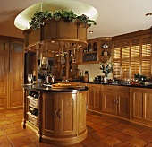 Holz-Einbauküche mit Kücheninsel, Steinfliesen und Holz-Jalousien