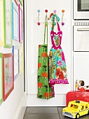 A colourful apron on the wall with toy on the floor in the kitchen