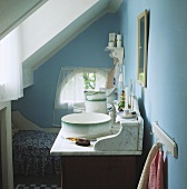Ein Waschtisch in einem blauen Schlafzimmer unter dem Dach