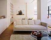 A light-coloured sofa in an open-plan living room