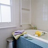 Badezimmer mit blauen Mosaikfliesen auf Badwannenwand