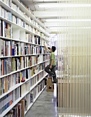 A man standing on a ladder in front of a bookshelf