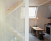 An open-plan dining room with a wooden table and a flight of stairs