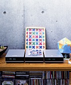 A hifi device and a CD on a wooden shelf