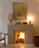 Kamin mit Naturdeko und Gemälde auf schlichter Steinumrahmung in modernem Wohnzimmer