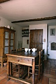 weiße Teekanne und Schalen auf antikem Holztisch mit passenden Stühlen in französischem Landhaus-Esszimmer