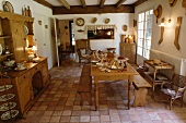 Tisch, Sitzbänke und Anrichte aus Kiefer in rustikalem Esszimmer mit Terracotta-Fliesen