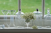 Antike Glasvasen und Flaschen auf weißem Fensterbrett